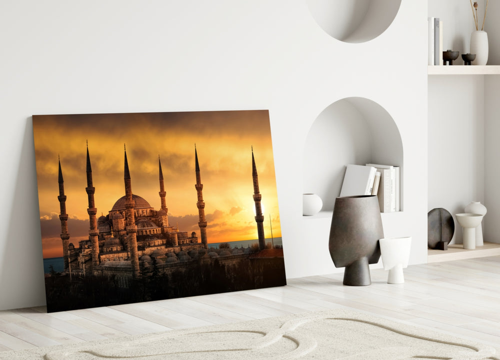 Close-up detail of slender minarets against a molten gold sky