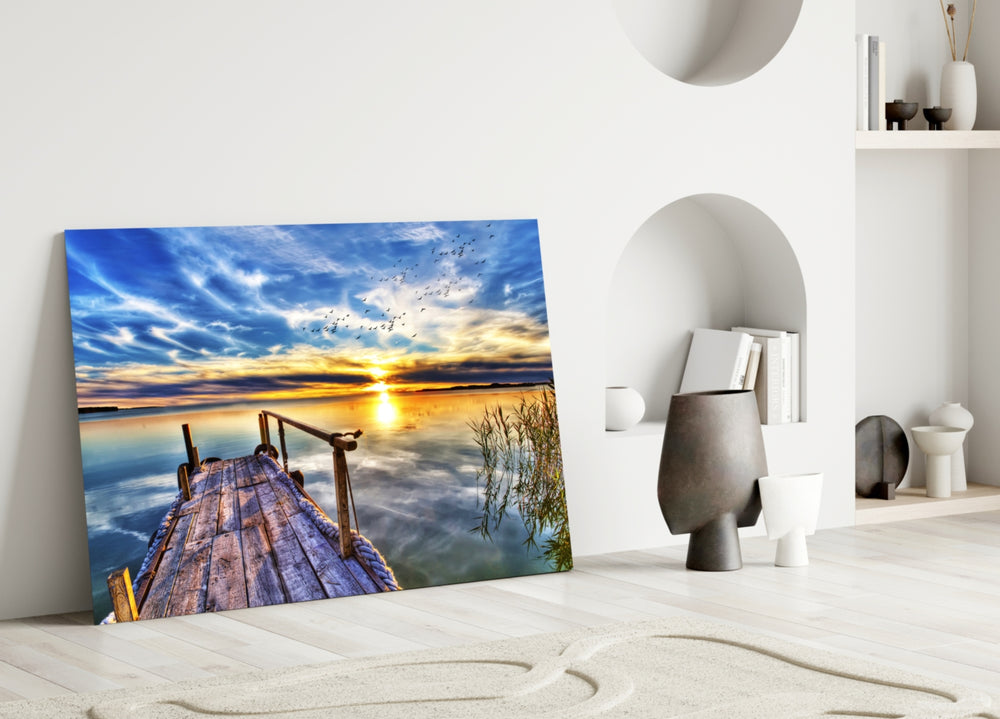 Close-up detail of weathered dock pointing toward a vivid sunset