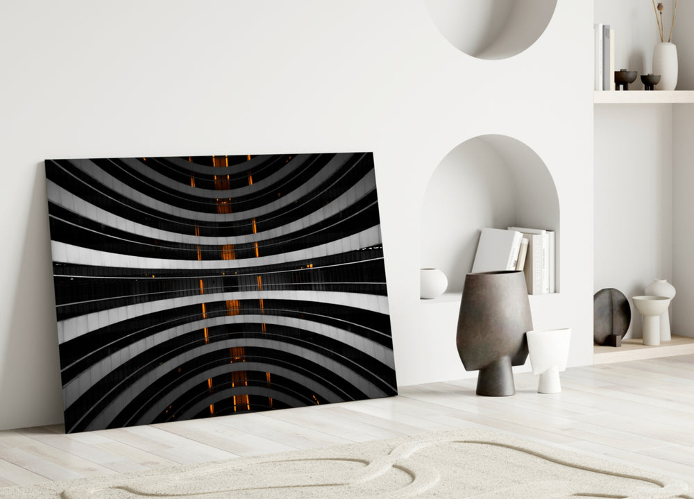 Close-up detail of glowing orange lights piercing curved monochrome balconies