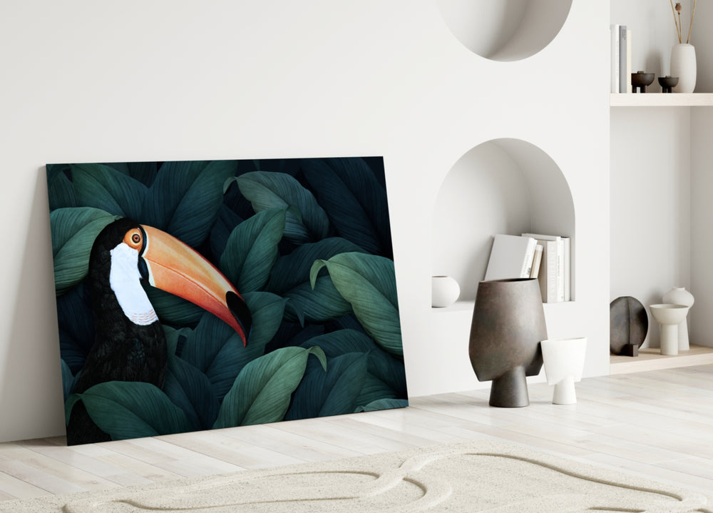 Close-up detail of toucan's orange beak among deep teal jungle leaves