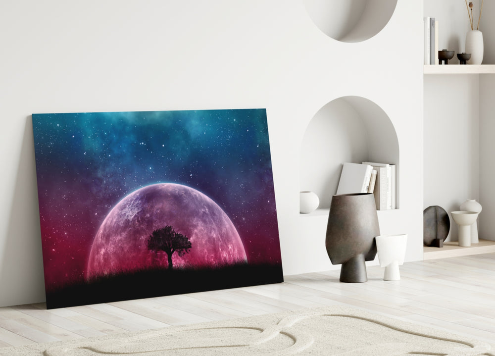 Close-up detail of magenta planet rising behind silhouetted tree