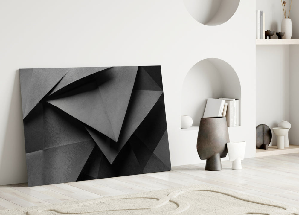 Close-up detail of folded triangular planes in charcoal monochrome