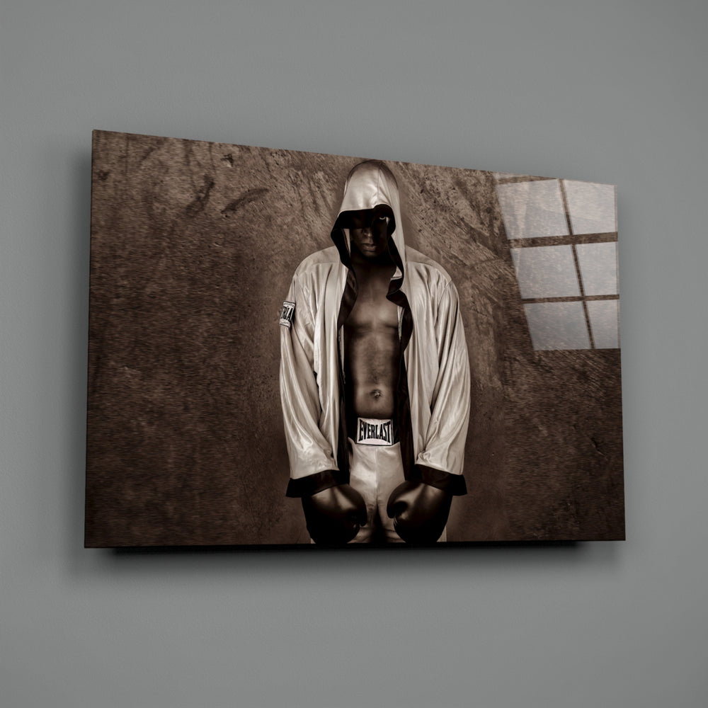 Close-up detail of hooded Ali with gloves behind glass