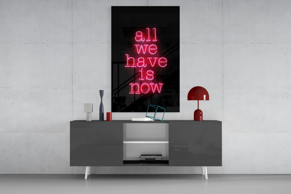 All We Have Is Now glass wall art catching light to reveal its painted glow
