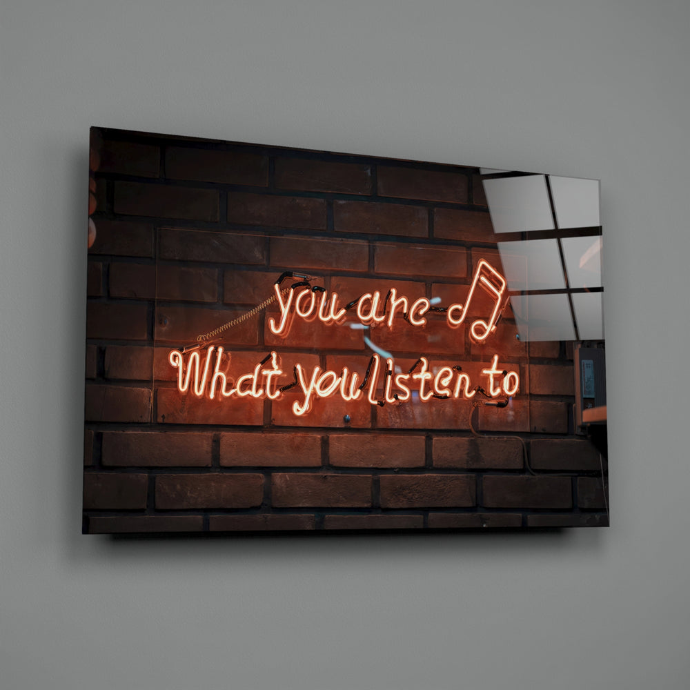 Close-up detail of tangerine neon music quote behind glass