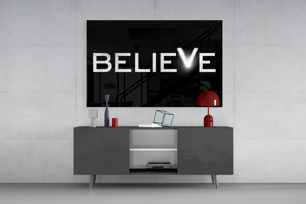 Believe glass wall art catching light to reveal its painted V
