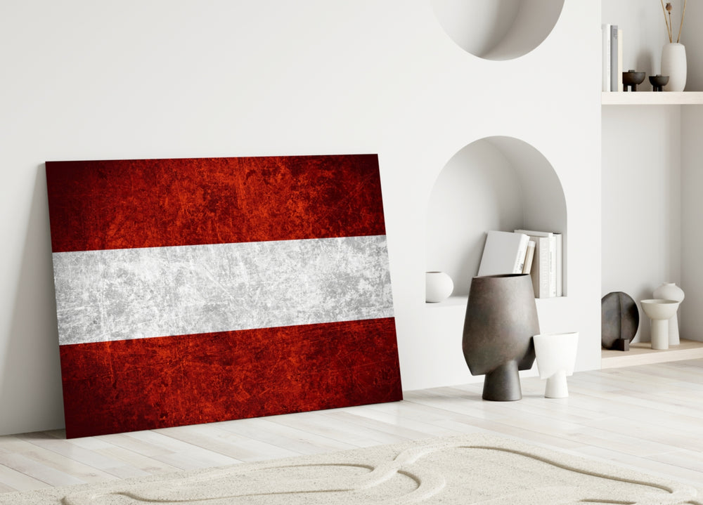 Close-up detail of scratched-metal Austrian tricolor behind glass