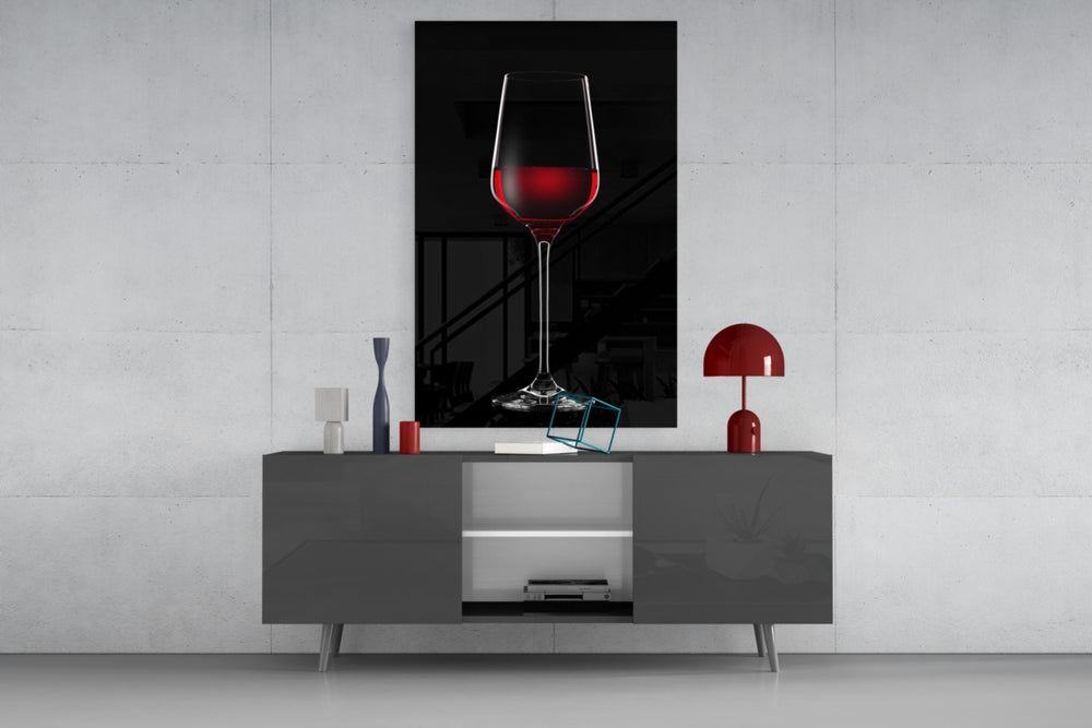 Wine glass wall art catching light to reveal its painted ruby tones