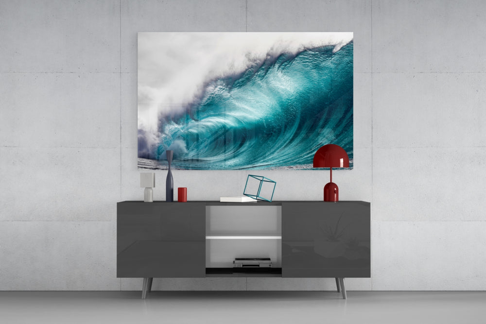 Wave glass wall art catching light to reveal its painted ocean tones