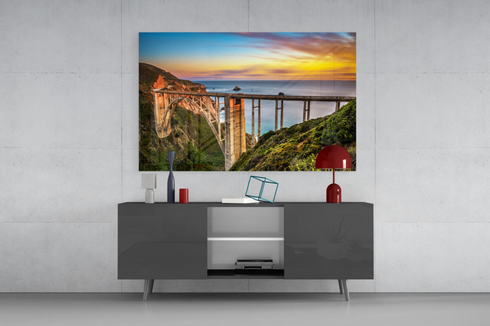Bixby Creek Bridge glass wall art catching light to reveal its painted sunset tones