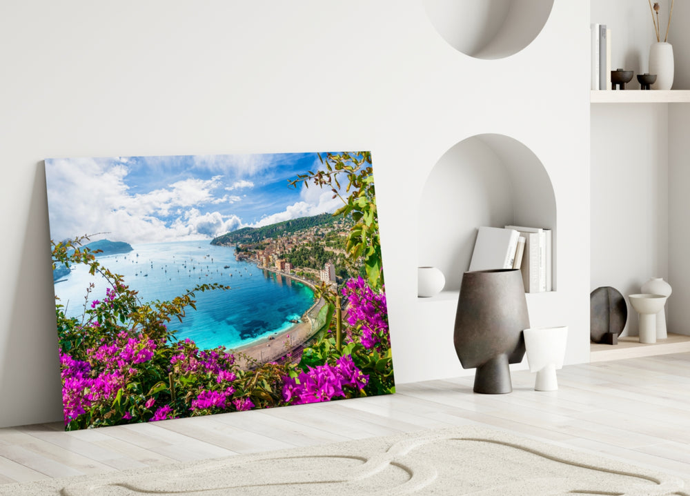 Close-up detail of bougainvillea and turquoise bay behind glass