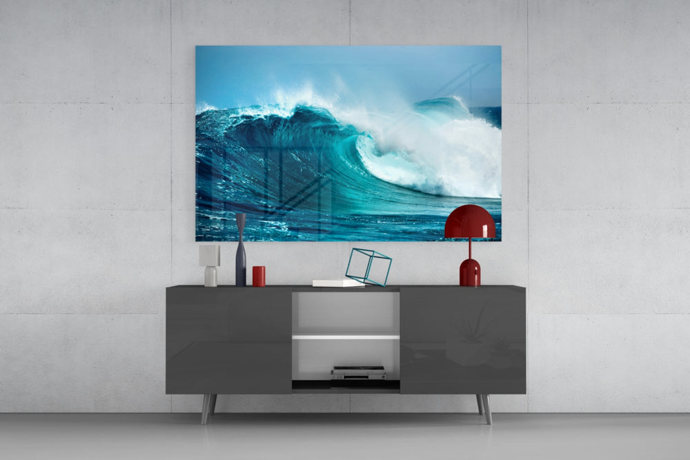 Waves glass wall art catching light to reveal its painted ocean tones