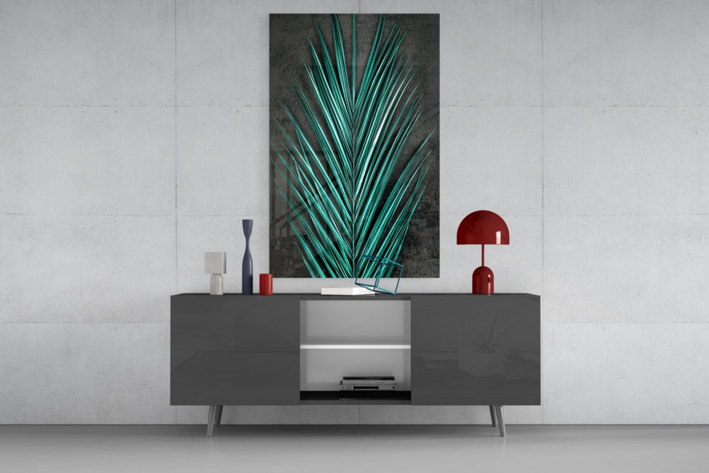 Areca Bunch glass wall art catching light to reveal its painted teal frond
