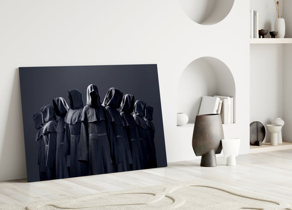Close-up detail of hooded coven robes behind glass