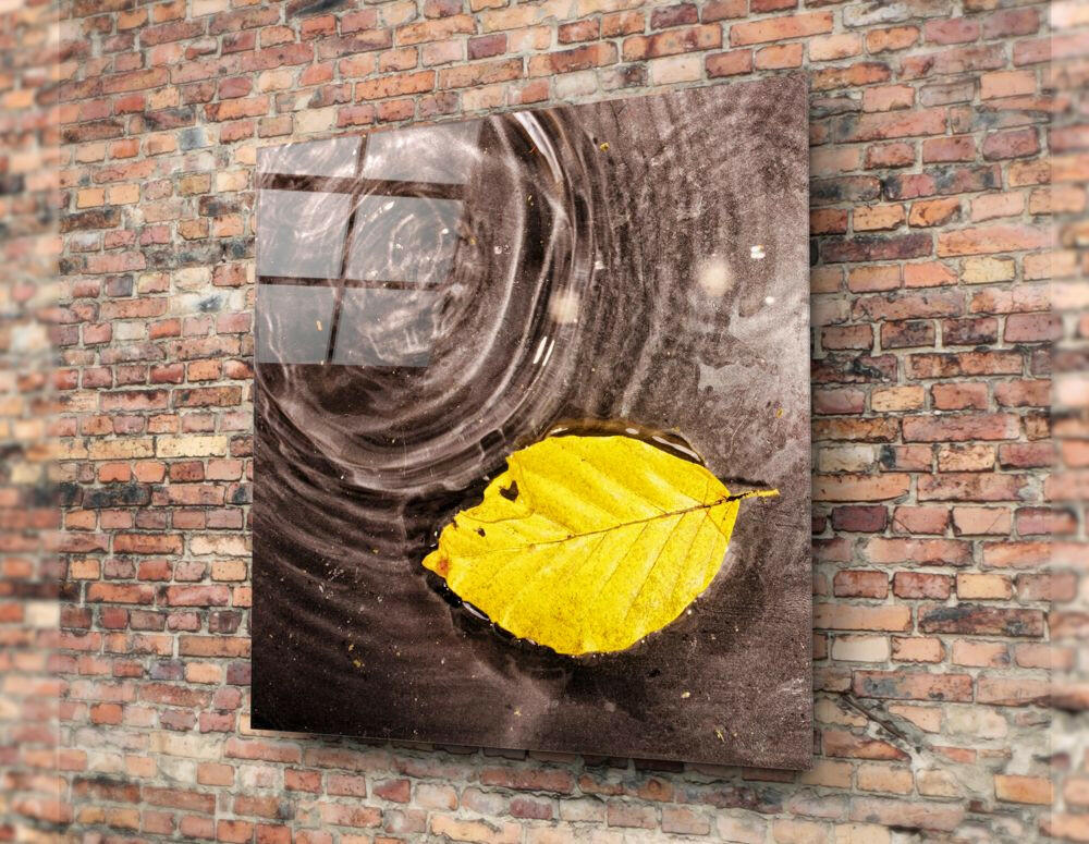Saffron-leaf on obsidian water cinematic glass wall art in hygge-bedroom