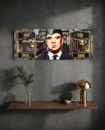 A gold-toned hundred-dollar note styled as a cinematic collage, with a front-facing portrait of a blue-eyed 1920s gangster in a pinstripe suit smoking a cigarette amid drifting smoke. panoramic glass wall art D