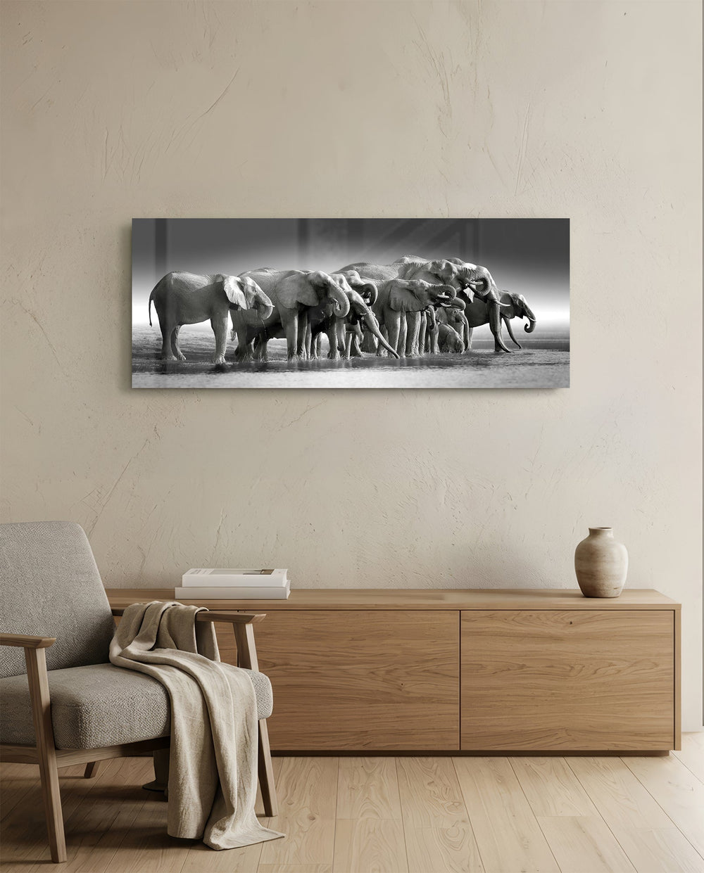 A herd of African elephants gathered at a waterline in soft black and white. panoramic glass wall art A