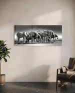 A herd of African elephants gathered at a waterline in soft black and white. panoramic glass wall art C
