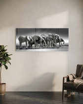 A herd of African elephants gathered at a waterline in soft black and white. panoramic glass wall art C