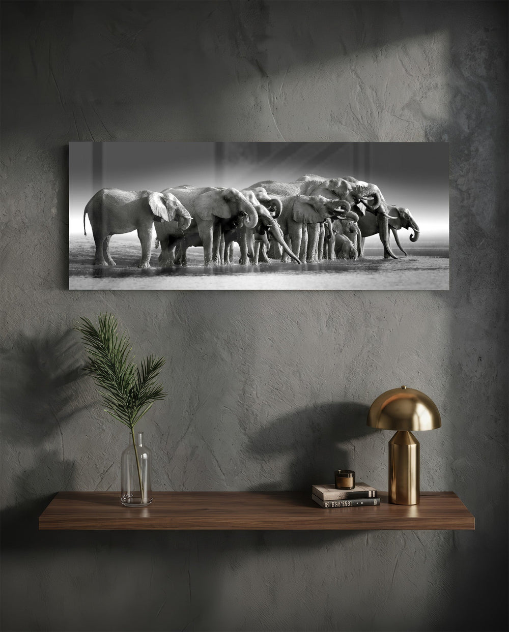 A herd of African elephants gathered at a waterline in soft black and white. panoramic glass wall art D