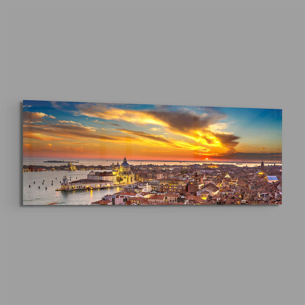 Aerial panoramic view of Venice at sunset, a great domed basilica and terracotta rooftops glowing beneath a fiery orange and blue sky over the lagoon. panoramic glass wall art E