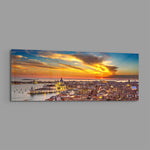 Aerial panoramic view of Venice at sunset, a great domed basilica and terracotta rooftops glowing beneath a fiery orange and blue sky over the lagoon. panoramic glass wall art E