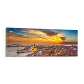 Aerial panoramic view of Venice at sunset, a great domed basilica and terracotta rooftops glowing beneath a fiery orange and blue sky over the lagoon. panoramic glass wall art F