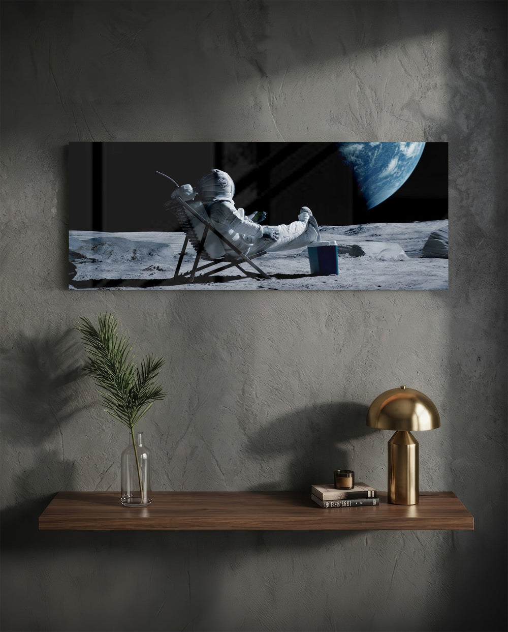 A spacesuited astronaut lounging in a deck chair on the lunar surface while planet Earth hangs in the black sky. panoramic glass wall art D