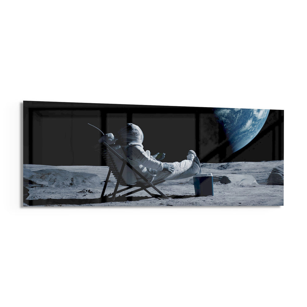 A spacesuited astronaut lounging in a deck chair on the lunar surface while planet Earth hangs in the black sky. panoramic glass wall art F