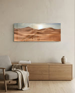 Rolling golden sand dunes rippling toward the horizon under a soft, hazy sun low in a pale sky. panoramic glass wall art A
