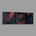 A moody close-up of tropical palm fronds glowing neon pink against deep, dark green jungle foliage. panoramic glass wall art E