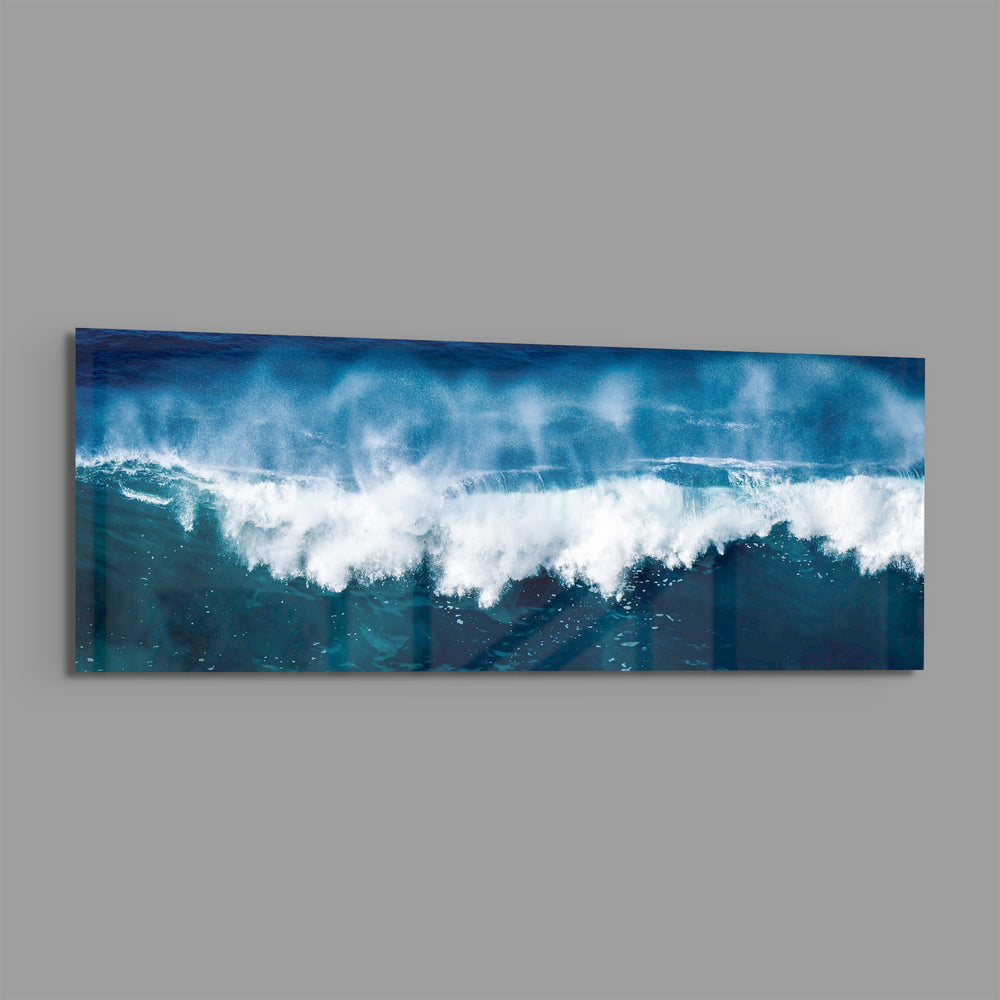 A powerful blue ocean wave breaking into white foam and spray across a wide panoramic seascape. panoramic glass wall art E