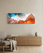 An aerial-style abstract fluid artwork of turquoise sea meeting coral-orange sand with lacy white foam. panoramic glass wall art A
