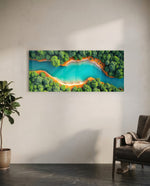 An aerial view of a winding turquoise river cutting through lush green forest with orange sandy banks. panoramic glass wall art C
