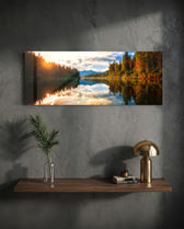 A mirror-calm lake at sunrise reflecting autumn forest, distant mountains, and a glowing cloudy sky. panoramic glass wall art D