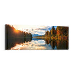 A mirror-calm lake at sunrise reflecting autumn forest, distant mountains, and a glowing cloudy sky. panoramic glass wall art F