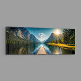 Panoramic alpine landscape of a mirror-calm lake with a wooden dock leading toward sunlit mountains and pine forest. panoramic glass wall art E