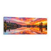 A blazing pink and orange sunset sky mirrored on a perfectly still forest lake. panoramic glass wall art F