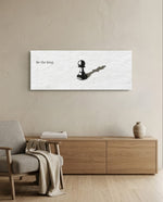 A single black chess pawn casting the long shadow of a king across a white textured surface, with a short motivational line of text panoramic glass wall art A