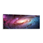 A glowing spiral galaxy swirling through clouds of pink, purple and blue across a star-filled cosmos. panoramic glass wall art F