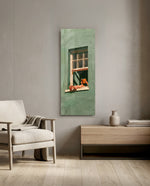 Minimalist illustration of a person lounging on a sill of a sage-green house, reading a book. panoramic glass wall art F