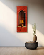 A seated figure reading on the sill of a terracotta-red arched niche, face hidden behind an open golden book. panoramic glass wall art A