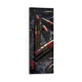 Dark, dramatic still life of crimson lipsticks shaped like brass cartridges, scattered with red lip prints, petals and water droplets. panoramic glass wall art D
