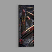 Dark, dramatic still life of crimson lipsticks shaped like brass cartridges, scattered with red lip prints, petals and water droplets. panoramic glass wall art E