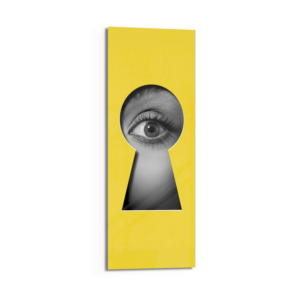 A black-and-white human eye peering out through a keyhole-shaped cutout in a flat, bright-yellow surface. panoramic glass wall art D