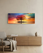 A lone tree with multicolored foliage standing on a small island, mirrored in still water beneath a fiery, cloud-swept sunset sky. panoramic glass wall art A