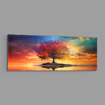 A lone tree with multicolored foliage standing on a small island, mirrored in still water beneath a fiery, cloud-swept sunset sky. panoramic glass wall art E