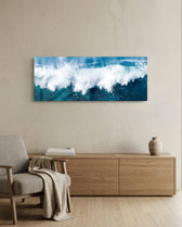 A powerful ocean wave breaking into white foam and spray against deep teal and blue sea water. panoramic glass wall art A