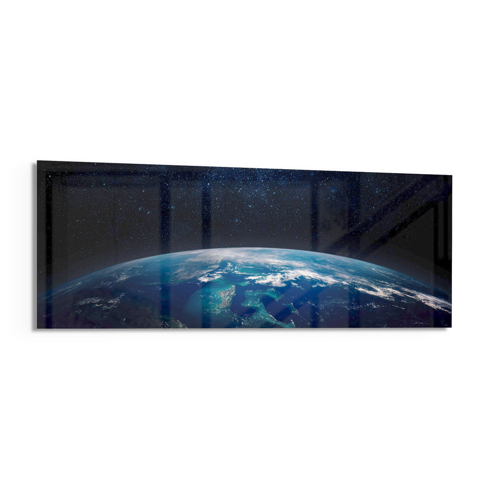 The curved edge of planet Earth seen from orbit, blue oceans and swirling clouds under a starry black sky. panoramic glass wall art F