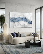 Ink Drift glass wall art displayed above a curved boucle sofa in a coastal living room